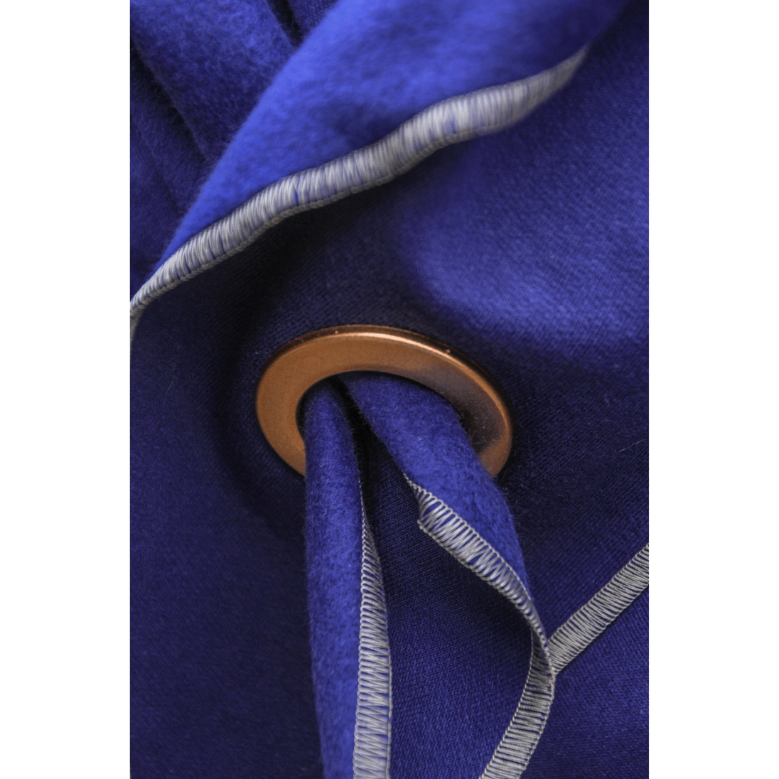 Handgemachtes XXL Dreieckstuch in Indigo Blau, mit goldener Oese. Nahaufnahme der Oese.