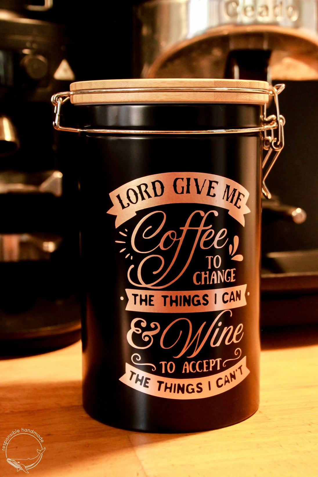 Schwarze Kaffeedose mit Bambusdeckel und Bügelverschluss in Kaffeebar, rosegoldener Spruch: LORD GIVE ME