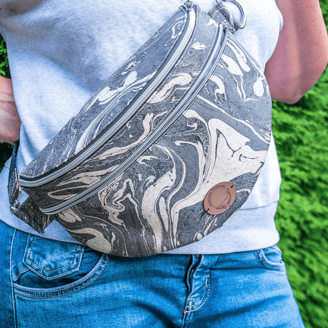 Tragebild der Slingbag aus handmarmoriertem Kork, Farbe schwarz und weiß mit zwei Reißverschlussfächern, Crossbody getragen