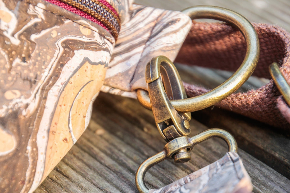 Detailbild der Grurtbandaufhängung an einem goldenen D-Ring und Karabiner der Slingbag aus handmarmoriertem Kork, Farbe braun und weiß 